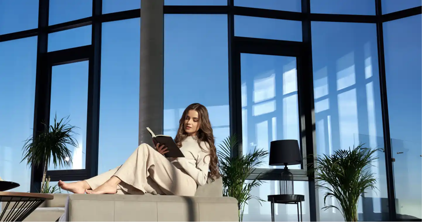 A woman reading by a wall of Windowz by Ozone panoramic windows